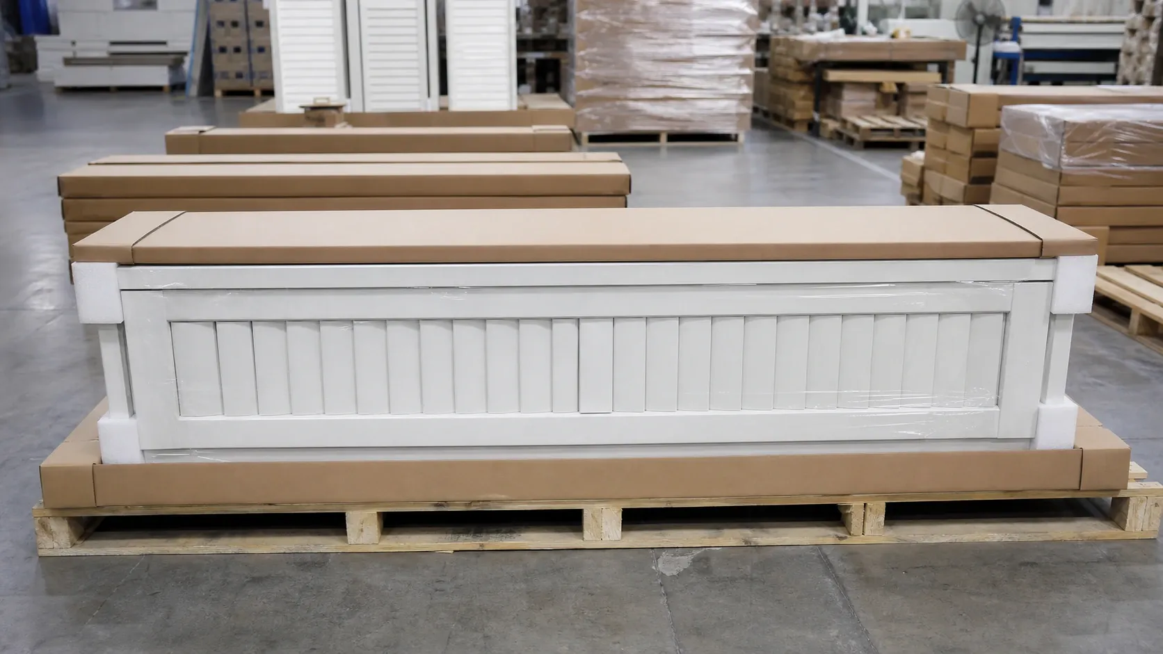 Factory worker wrapping finished shutters with protective export packaging